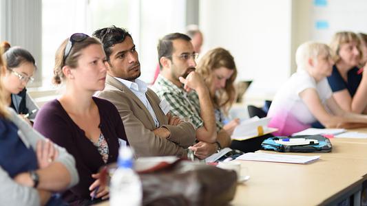 Postgraduate research students listening to a talk