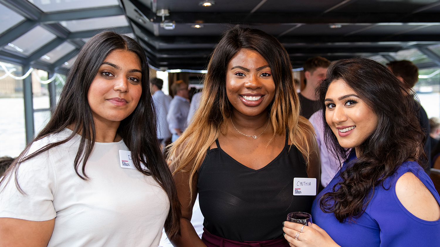 Three alumni holding drinks during the London alumni network
Summer Social, July 2018