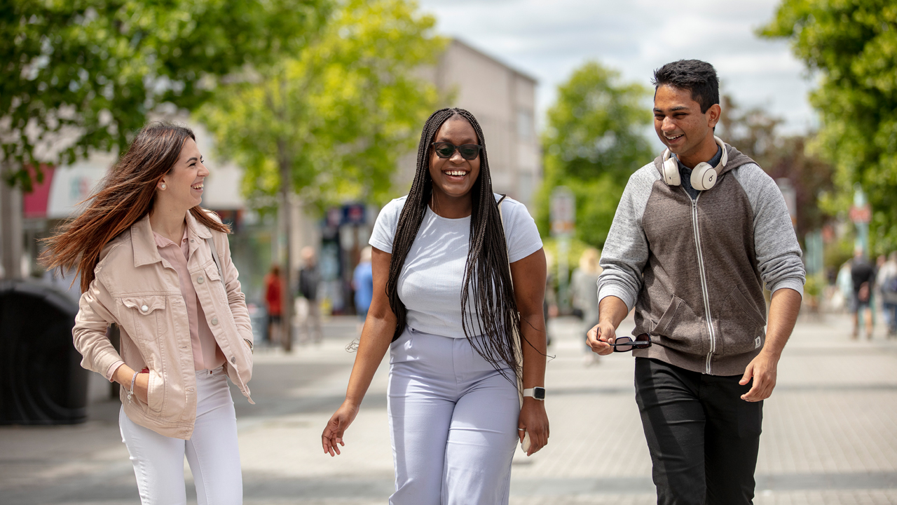 International students in the city centre laughing and walking.