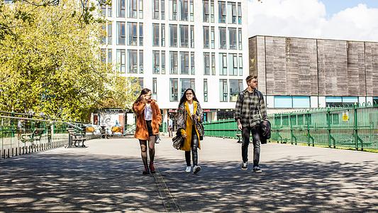 A group of students walking across Plymouth campus near Drakes Place and the Reservoir Cafe