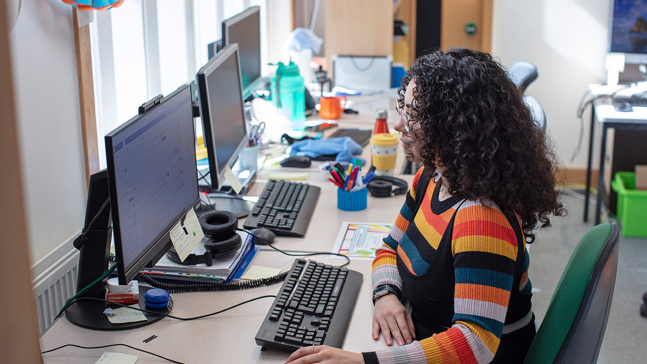Student working at a computer screen in the Babylab (flipped)