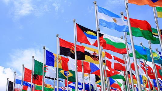 World flags flying against a blue sky (full-bleed)