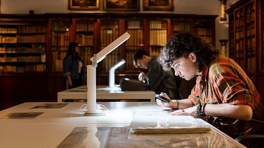 Brodrick (Brodie) Butchart - Anthropology student is looking through a magnifier during a visit the Box in Plymouth. Museum and Art Gallery. 