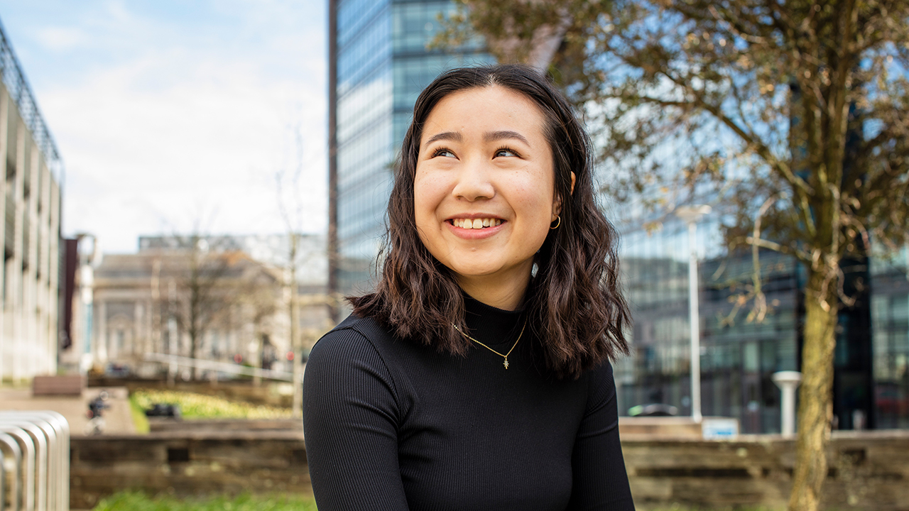 Girl sitting outside Roland Levinsky Building