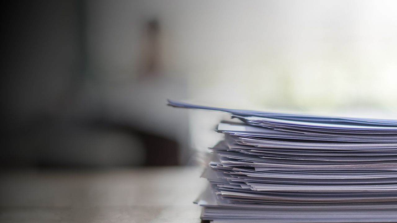 documents or paperwork stacked up on a table